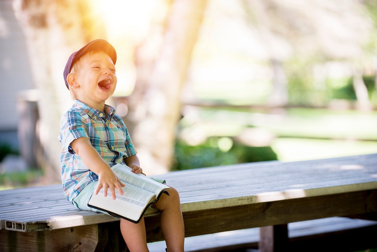 kid reading book and laughing