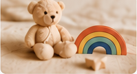 Teddy bear beside a rainbow toy