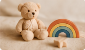 Teddy bear beside a rainbow toy